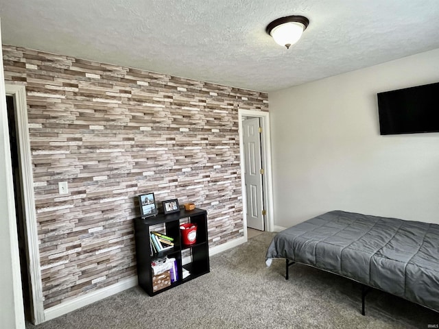 carpeted bedroom featuring a textured ceiling and baseboards