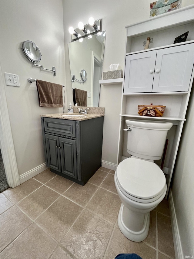 bathroom with tile patterned flooring, vanity, toilet, and baseboards