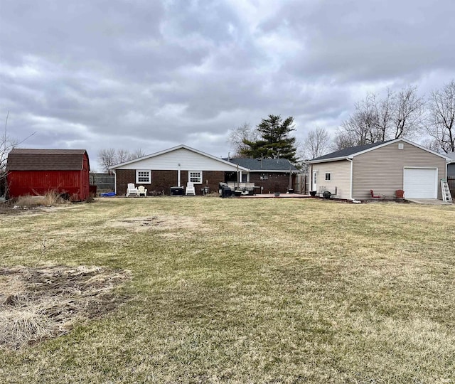 rear view of house with a yard and an outdoor structure