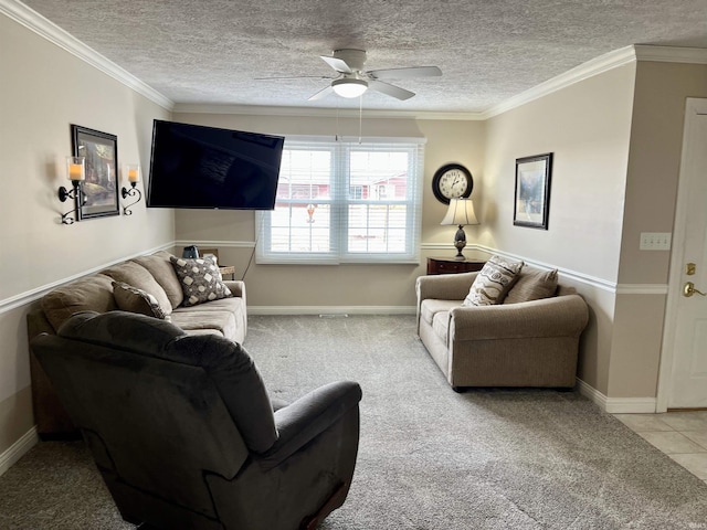 carpeted living area featuring baseboards, a ceiling fan, tile patterned floors, a textured ceiling, and crown molding