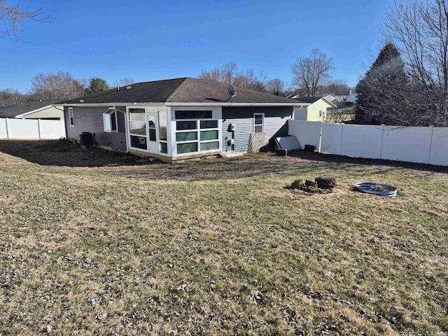 back of house with a fenced backyard, cooling unit, and a yard