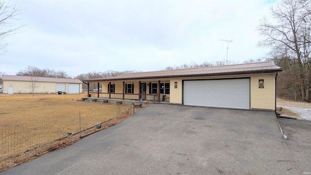 single story home with a front yard, covered porch, and metal roof