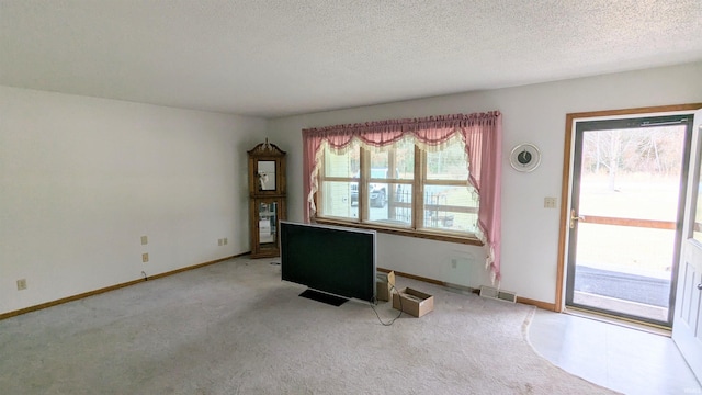 interior space featuring baseboards, a textured ceiling, visible vents, and carpet flooring