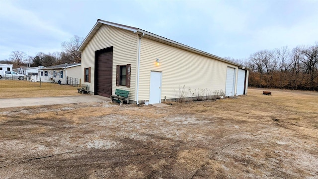 view of side of home with a garage and an outbuilding