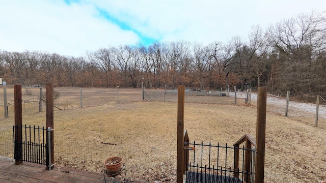 view of yard with a gate, fence, and a rural view