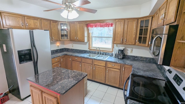 kitchen featuring stainless steel appliances, brown cabinets, a sink, and light tile patterned floors