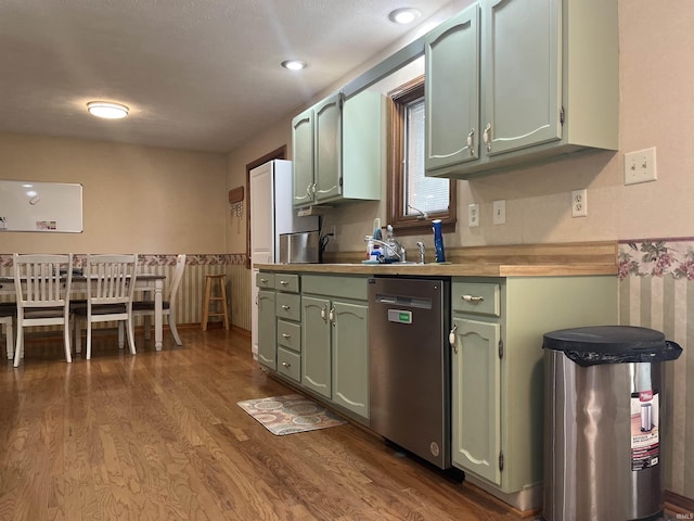 kitchen with recessed lighting, dark wood-style flooring, green cabinetry, and dishwasher