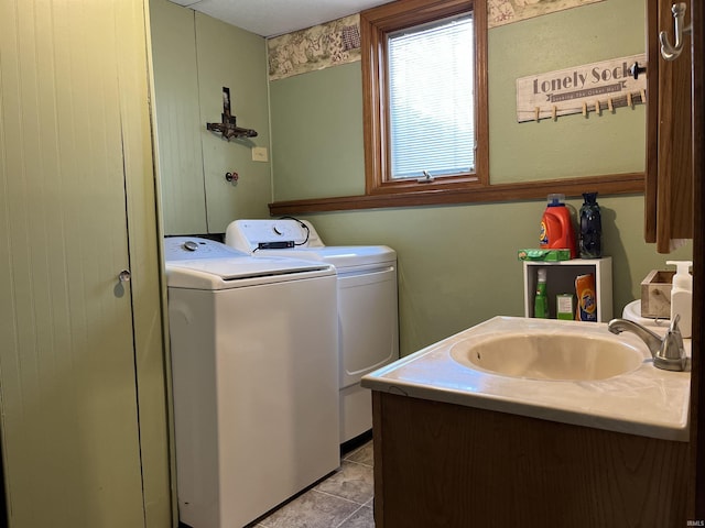 clothes washing area featuring laundry area, washer and dryer, a sink, and tile patterned floors