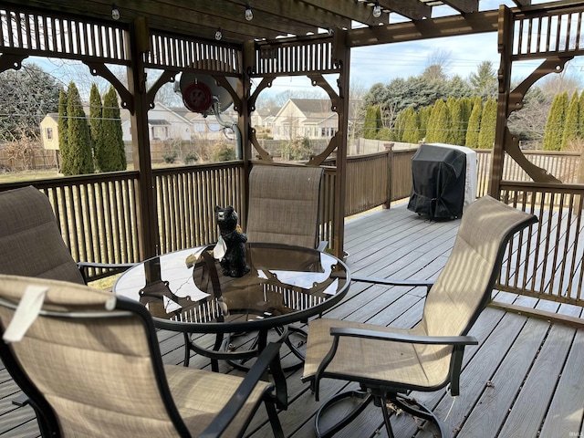 wooden deck featuring a grill, outdoor dining area, and a pergola