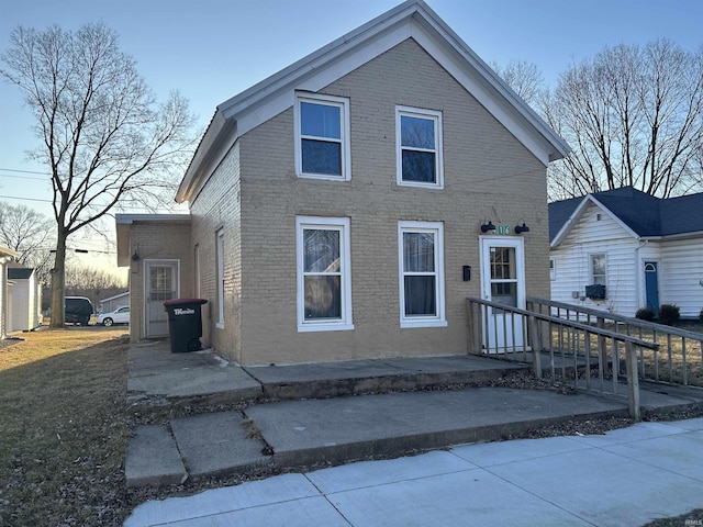 view of front of house featuring a patio and brick siding