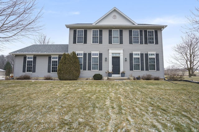 view of front facade featuring a shingled roof and a front lawn