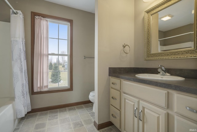 bathroom featuring toilet, baseboards, a wealth of natural light, and vanity