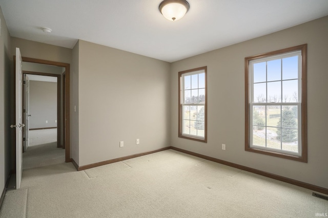 unfurnished room featuring light carpet, visible vents, and baseboards