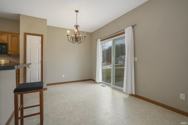 unfurnished dining area with visible vents, baseboards, and a notable chandelier