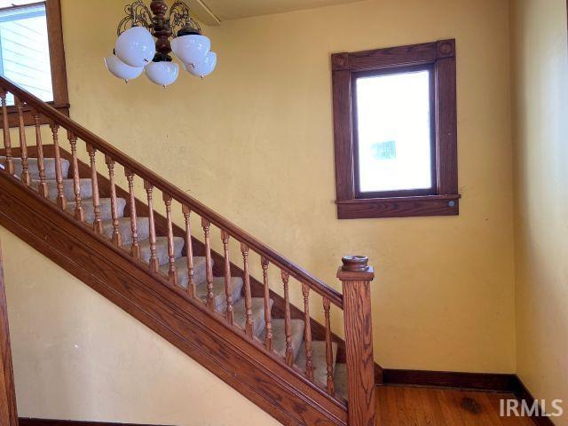 staircase featuring plenty of natural light, baseboards, and wood finished floors