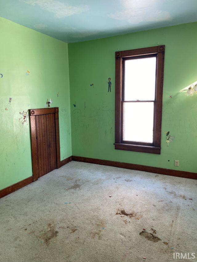 unfurnished room featuring baseboards and carpet flooring