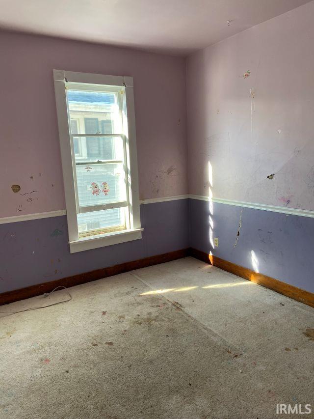 spare room featuring carpet floors and baseboards