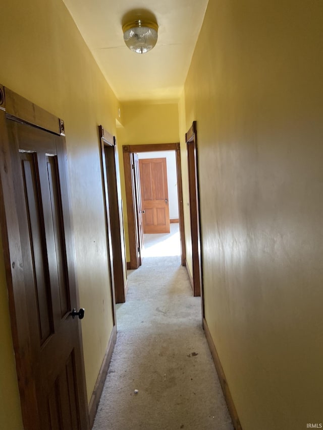 corridor with light colored carpet and baseboards