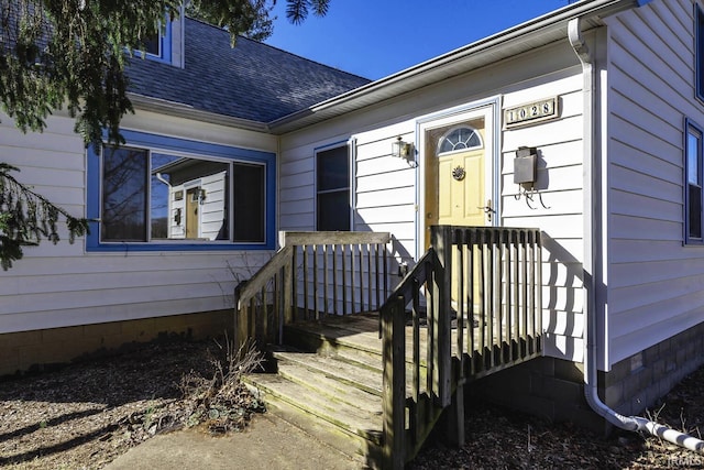 doorway to property with a shingled roof