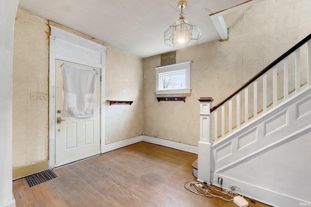 entrance foyer with visible vents, stairs, baseboards, and wood finished floors