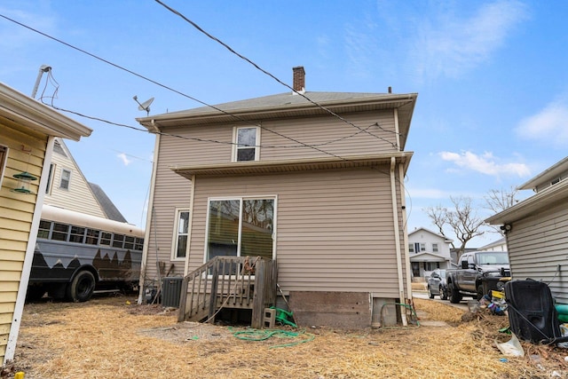 back of property featuring central air condition unit and a chimney