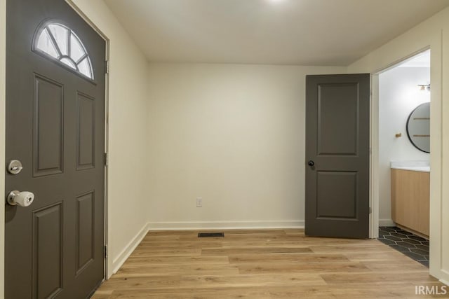 entrance foyer with light wood finished floors, visible vents, and baseboards