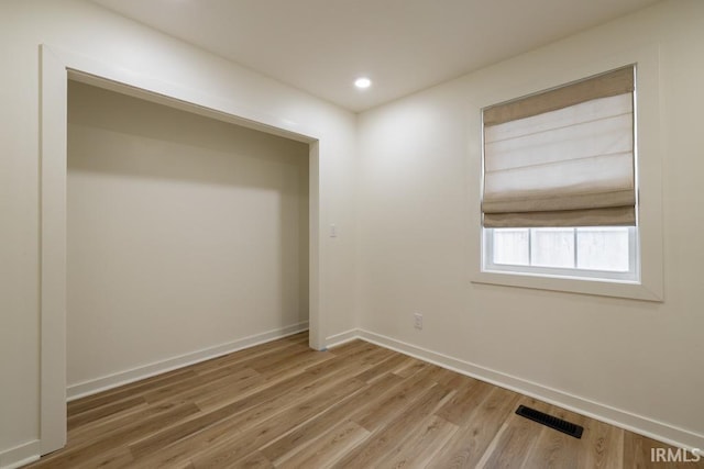 spare room with visible vents, baseboards, wood finished floors, and recessed lighting