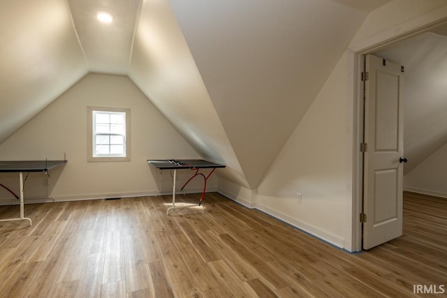 additional living space with lofted ceiling, baseboards, and wood finished floors