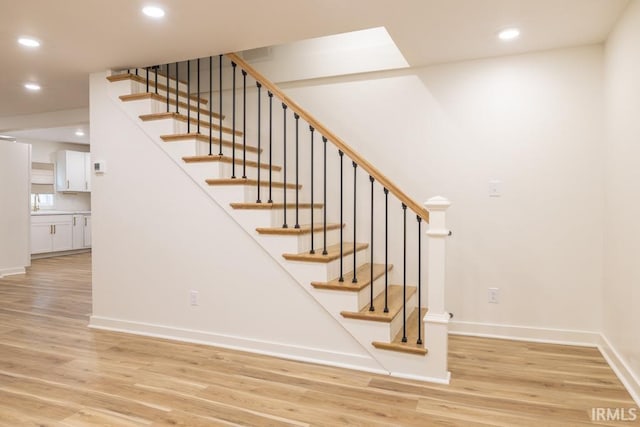 staircase with recessed lighting, baseboards, and wood finished floors