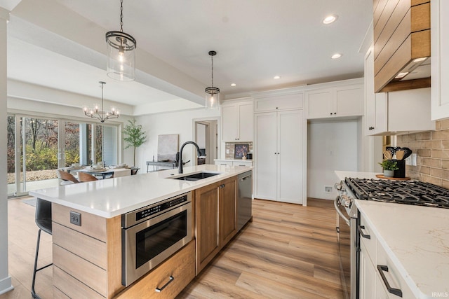 kitchen with tasteful backsplash, appliances with stainless steel finishes, light countertops, and a sink