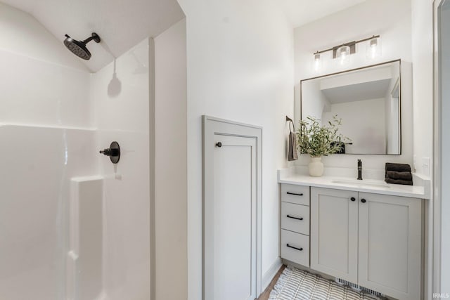 bathroom featuring a shower and vanity