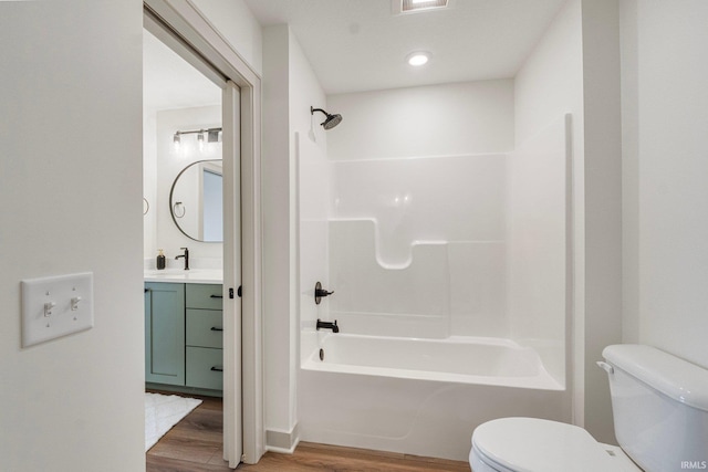 full bathroom with toilet, shower / bath combination, wood finished floors, visible vents, and vanity