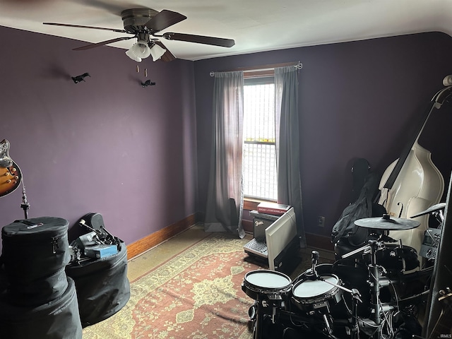 interior space with ceiling fan and baseboards