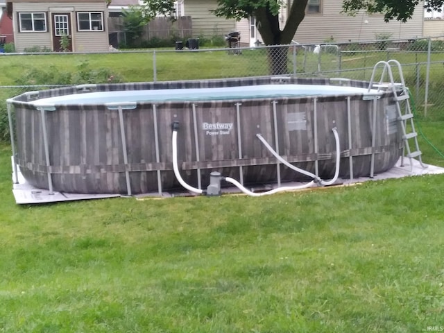 outdoor pool featuring a lawn and fence