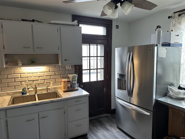 kitchen featuring light wood finished floors, light countertops, a sink, and stainless steel fridge with ice dispenser