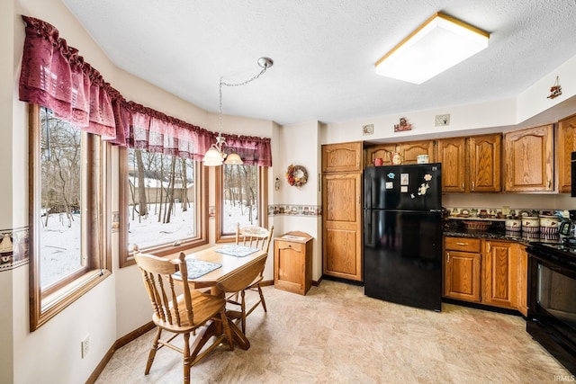 kitchen with brown cabinetry, freestanding refrigerator, range, and dark countertops