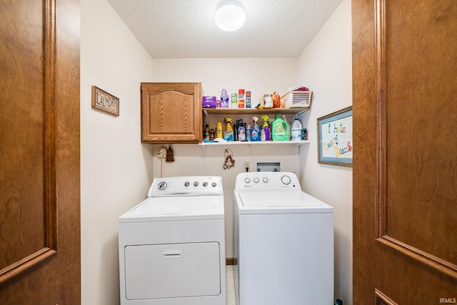 laundry room with cabinet space, a textured ceiling, and washer and dryer