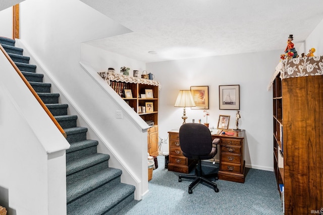 office featuring carpet floors, baseboards, and a textured ceiling