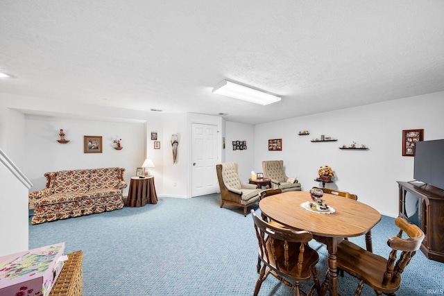 dining room featuring a textured ceiling, carpet floors, and baseboards