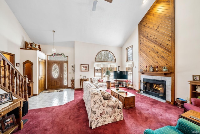 living area with a fireplace, dark colored carpet, high vaulted ceiling, dark tile patterned flooring, and stairs