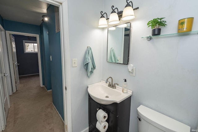 bathroom featuring baseboards, vanity, and toilet