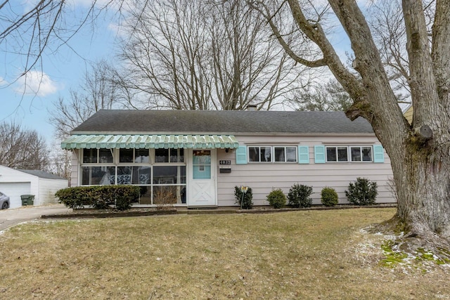 single story home with a front lawn and an outdoor structure