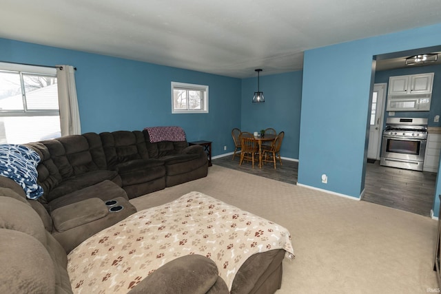 carpeted living area with a wealth of natural light and baseboards