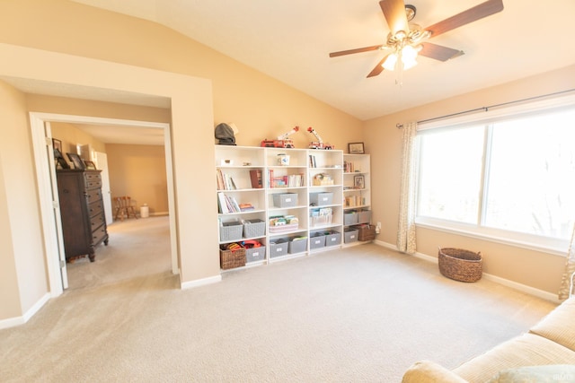 living area featuring vaulted ceiling, carpet floors, a ceiling fan, and baseboards