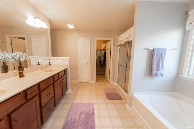 full bath featuring double vanity, a stall shower, tile patterned floors, a sink, and a bath