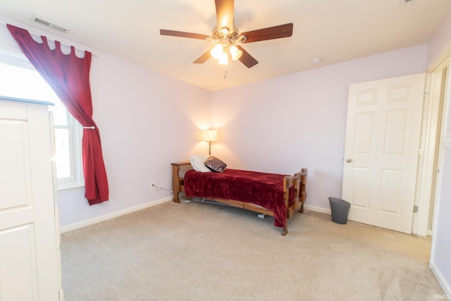 bedroom with carpet floors, baseboards, visible vents, and a ceiling fan