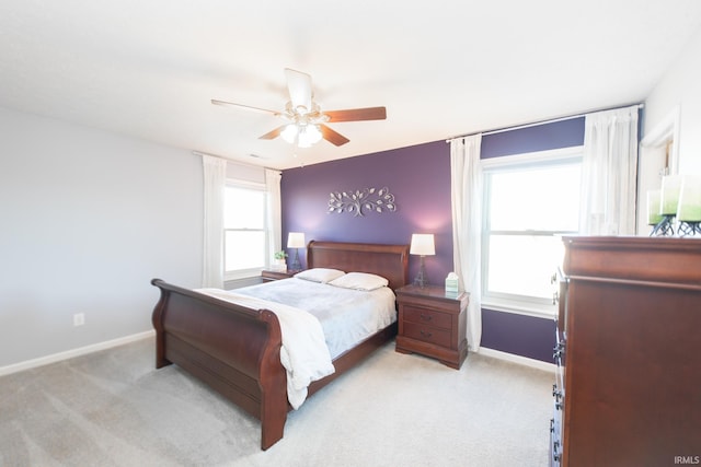 bedroom featuring light carpet, ceiling fan, and baseboards