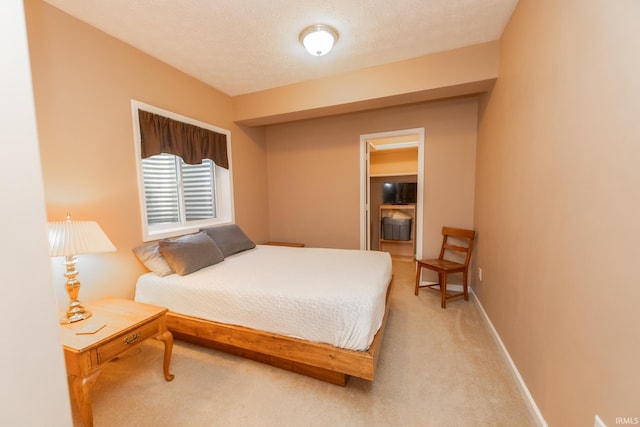 bedroom featuring carpet floors, a textured ceiling, and baseboards