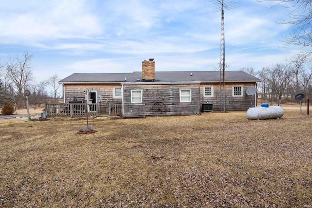 back of house featuring a yard, a chimney, cooling unit, and a wooden deck