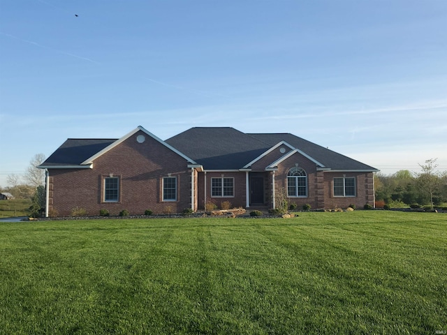 single story home featuring brick siding and a front yard